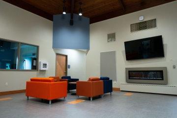 Chairs, fireplace, and television in the new Wilcox Center.